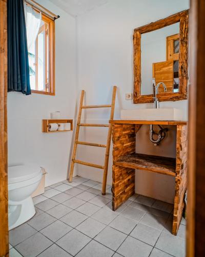 a bathroom with a sink and a mirror and a toilet at Rascal House Gili Trawangan in Gili Trawangan