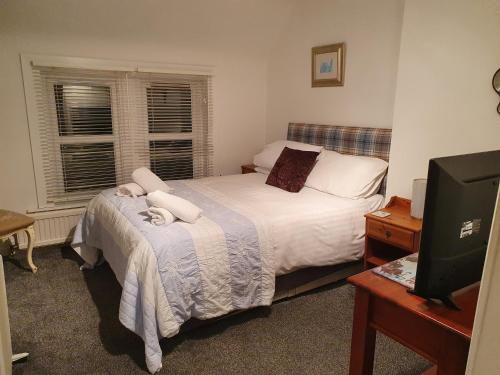 a small bedroom with a bed and a television at The craw inn in Eyemouth