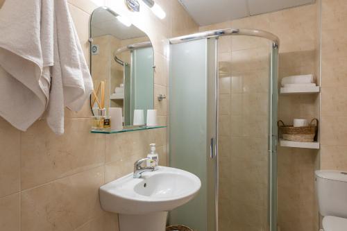 een badkamer met een wastafel en een douche bij Aquamarine in Pomorie