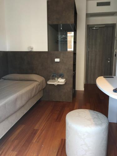 a bedroom with a bed and a stool and a sink at Hotel Italy in Bibione