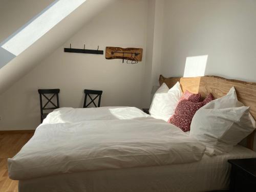 a bedroom with a bed with white sheets and pillows at Gästehaus Lausnitz Ferienwohnung, Reda in Lausnitz