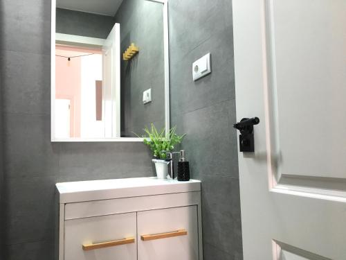 a bathroom with a white sink and a mirror at Mar y Arena - 5 minutos a la playa y al centro in Santa Pola