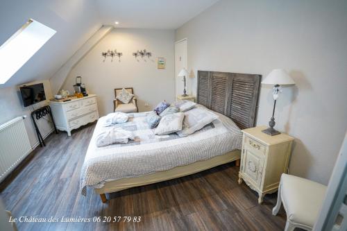 een slaapkamer met een groot bed en een dressoir bij Le Château des Lumières de la Baie de Somme in Saint-Blimont