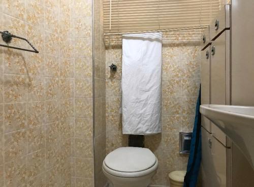 y baño con aseo y lavamanos. en Loft aconchegante, en São Vicente