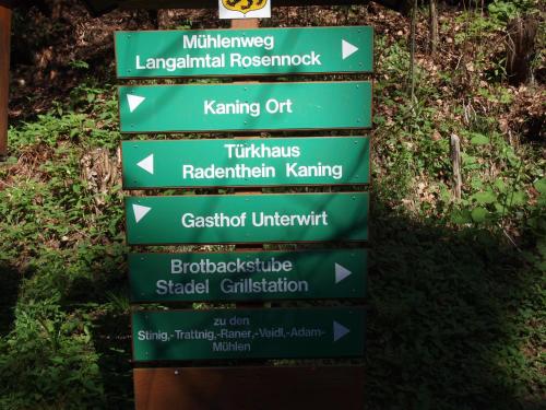 a sign with arrows pointing in different directions at Landhaus Alpentraum in Kaning