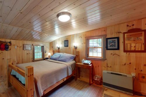 1 dormitorio con 1 cama en una cabaña de madera en Pebble Beach, en The Highlands