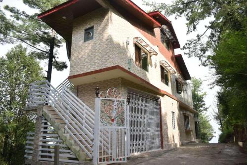 a house with a white door and a gate at Janjua lodges Murree in Murree