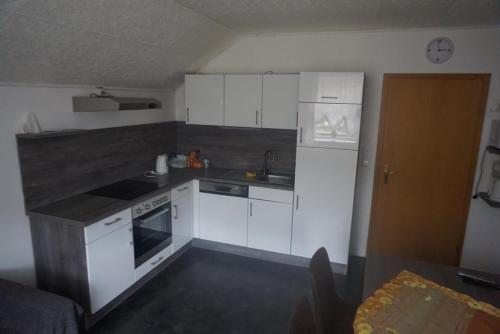 a small kitchen with white cabinets and a stove at Haus Barbara Stangl 2 in Pruggern