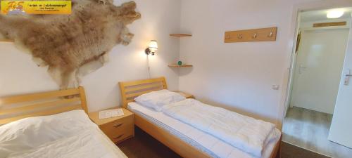 a bedroom with two beds and a painting on the wall at Haus Enzian by FiS - Fun in Styria in Bad Mitterndorf