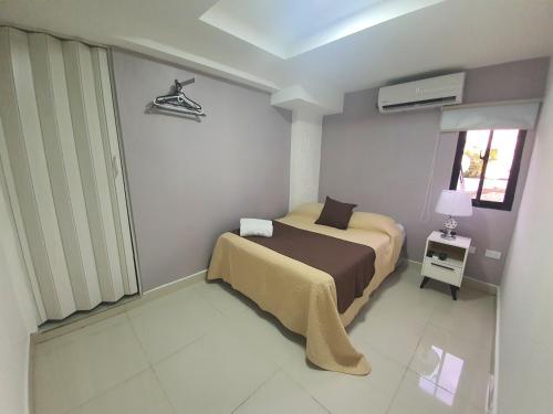 een kleine slaapkamer met een bed en een raam bij Malecon Premium Rooms & Hotel in Santo Domingo