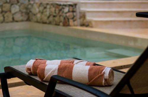 - une serviette assise sur une table à côté de la piscine dans l'établissement Hotel Boutique SAYAB, à Valladolid