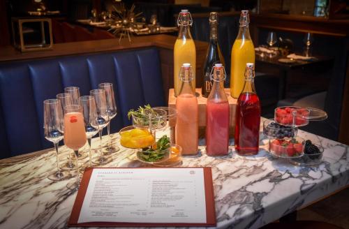 a table with bottles and glasses of drinks on it at The Darcy Hotel, Washington DC in Washington