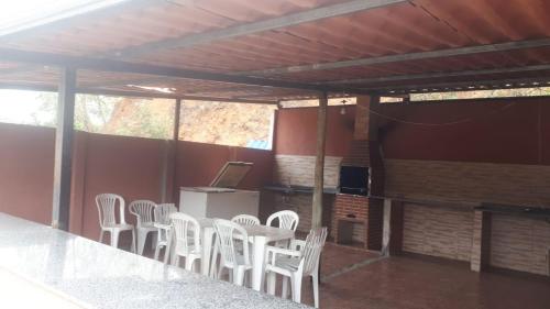 a group of white chairs sitting in a room at Pousada Kart Clube in São João del Rei
