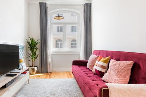 salon z czerwoną kanapą i oknem w obiekcie Augusta Street 213 - 3 Dto - Your Home in Lisbon w Lizbonie