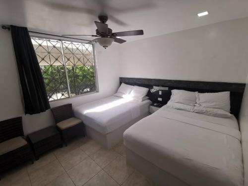 a bedroom with two beds and a window at The Balboa Inn in Panama City