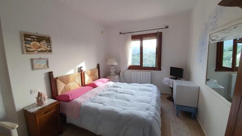 a bedroom with a large bed with pink pillows at B&B La Murichessa in Arzachena