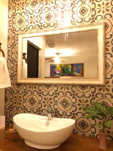 a bathroom with a white sink and a mirror at El Roble Hotel in Bacalar