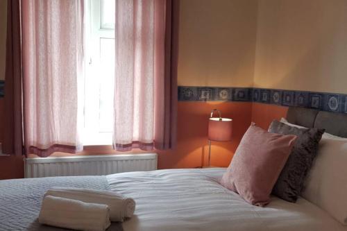 a bedroom with a white bed with a window at Delight Marvel-Derby House at Maidstone in Maidstone