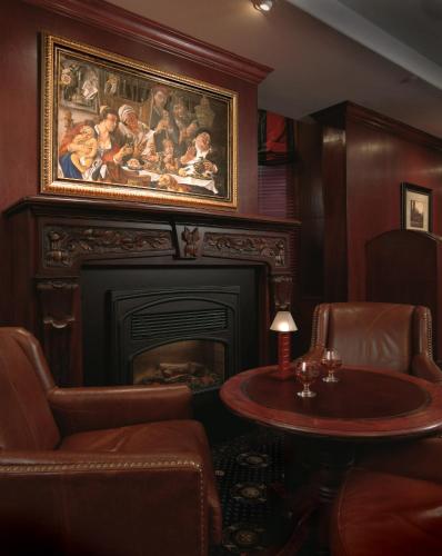 a living room with a fireplace and a table and chairs at Chateau Louis Hotel & Conference Centre in Edmonton