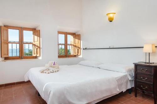 a bedroom with a white bed and a white dresser at Petit Hotel Hostatgeria La Victoria in Alcudia