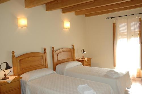 a bedroom with two beds and a window at Casa con piscina y vistas a montaña - Cal Solsona in La Baronia de Rialb