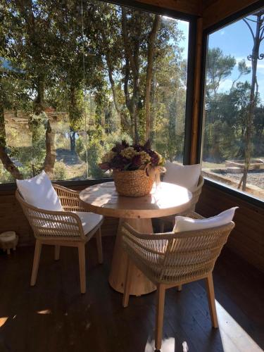a porch with a table and chairs and a window at Mas de l'Arlequi in Rojals