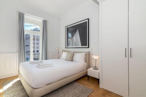 a white bedroom with a white bed and a window at The Boulevard by The Good Neighbour in Lisbon in Lisbon