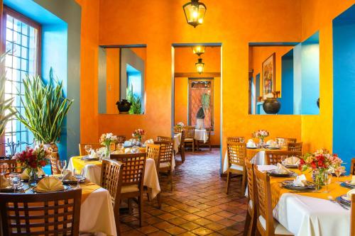 a dining room with tables and chairs with yellow walls at Hotel Posada El Paraíso in San Cristóbal de Las Casas