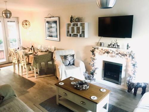a living room with a table and a fireplace at Chestnut Cottage, Shanklin Rural Retreat in Shanklin