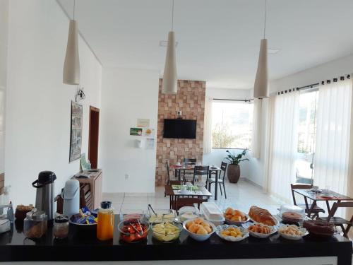 POUSADA LIMAS SUITES في كابيتوليو: مطبخ مع طاولة عليها طعام