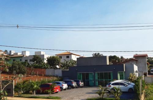 un estacionamiento con autos estacionados frente a un edificio en POUSADA LIMAS SUITES, en Capitólio