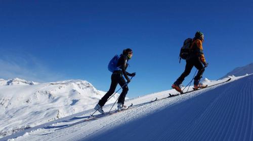 two people are skiing down a snow covered mountain at Duplex a la plaça Major in El Pont de Suert