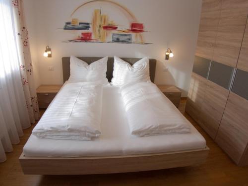 a bedroom with two beds with white sheets and pillows at Appartement Gandler in Valdaora