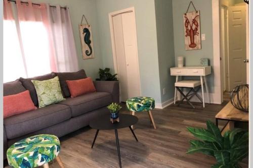 a living room with a couch and a table at The Comfi Coral - 2 Bed Apartment Home Studio B in Baytown