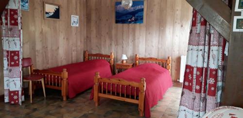 - une chambre avec 2 lits et des couvertures rouges dans l'établissement GERFAUD Appartements en chalet, à Saint-Gervais-les-Bains