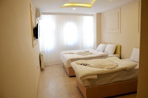 two beds in a room with a window at Sultanahmet çoşkun hotel in Istanbul