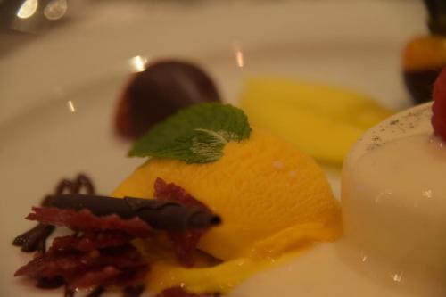 a plate of food with a dessert and a candle at Hotel-Restaurant Große-Wilde in Bottrop