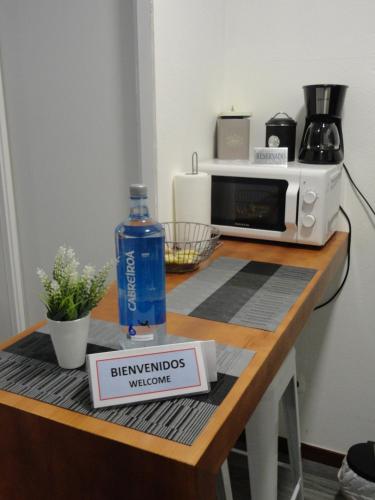 una mesa con microondas y una botella de agua. en Estancia acogedora en Vigo en Vigo