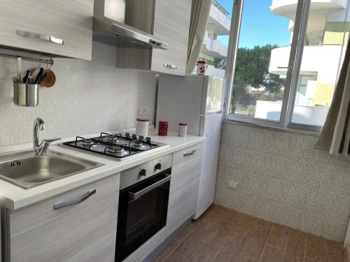 a kitchen with a stove and a sink and a window at My House in Montesilvano