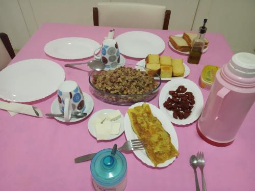a pink table topped with plates of food on a table at Casa Familiar Gilda in Ribeira Grande