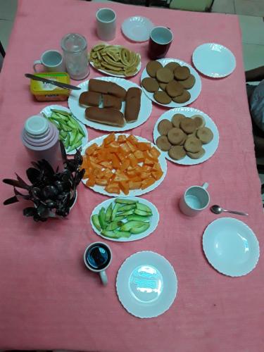 a pink table with plates of food on it at Casa Familiar Gilda in Ribeira Grande
