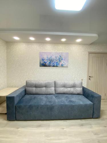 niebieska kanapa w pokoju z obrazem na ścianie w obiekcie Suite Mira Avenue Center Двухкомнатная Квартира в центре возле ТЦ ЦУМ w mieście Czernihów