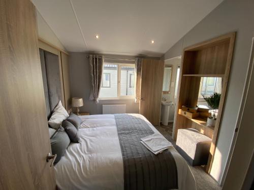 a bedroom with a bed and a window at Sea view beach lodge Trecco bay 3 bedroom in Porthcawl