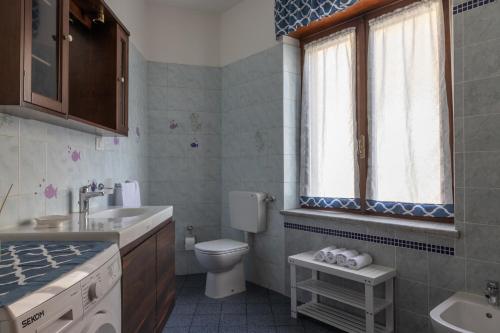 een badkamer met een wastafel, een toilet en een raam bij Les 2 Soeurs in Pont-Saint-Martin