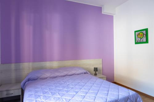a bedroom with purple walls and a bed at Les 2 Soeurs in Pont-Saint-Martin