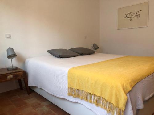 a bedroom with a bed with a yellow blanket at Casa do Côvo - Suite in Porto Covo
