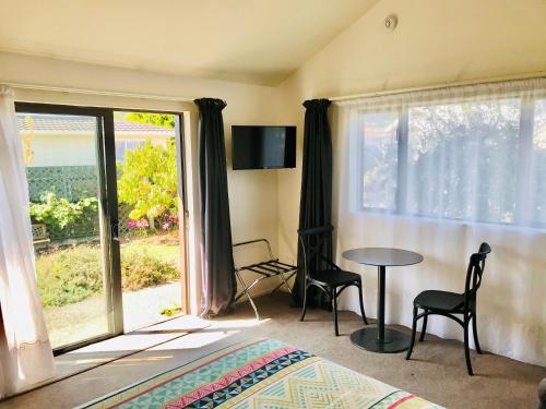 a bedroom with a bed and a table and a window at Studio on Parkers in Nelson