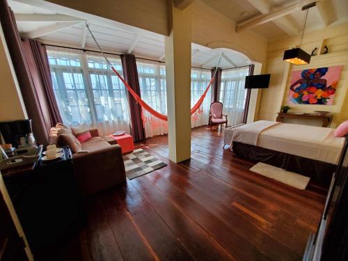 a bedroom with a bed and a living room at Prins Hendrik Suites in Paramaribo