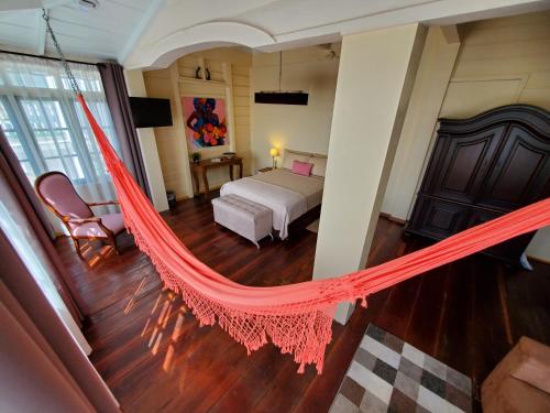 a bedroom with a bed and a hammock in it at Prins Hendrik Suites in Paramaribo