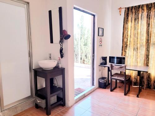 a bathroom with a sink and a desk and a window at Suite amplia privada a 8 min del centro in Aguascalientes